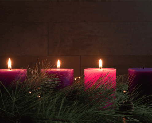 Three of the four Advent candles lit, the final candle unlit, highlighting the anticipation of the coming of Jesus.