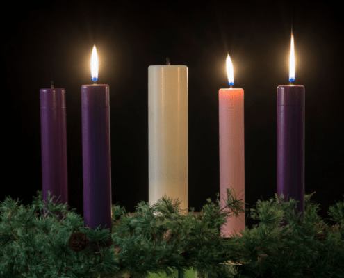 Four candles stand together lighting up the room.