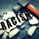 A hammer breaking what holds racism together.