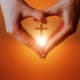 Hands in the shape of a heart with a cross in the middle
